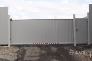 Промышленные автоматические ворота с отделкой сайдингом серого цвета